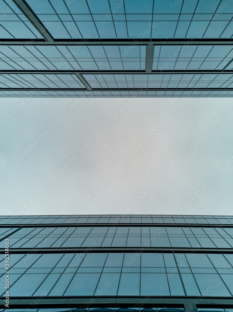 Upward view to two high corporate buildings full of windows