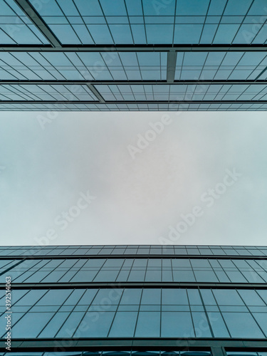 Upward view to two high corporate buildings full of windows
