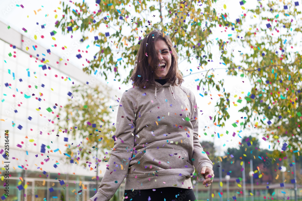Obraz premium young female having fun celebrating with confetti outdoor
