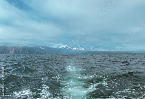 Snow covered volcano view from the stormy sea