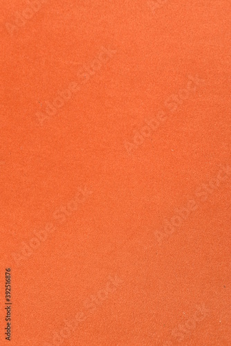 On a vertical orange fabric background, a frame made of live fluffy pine branches.