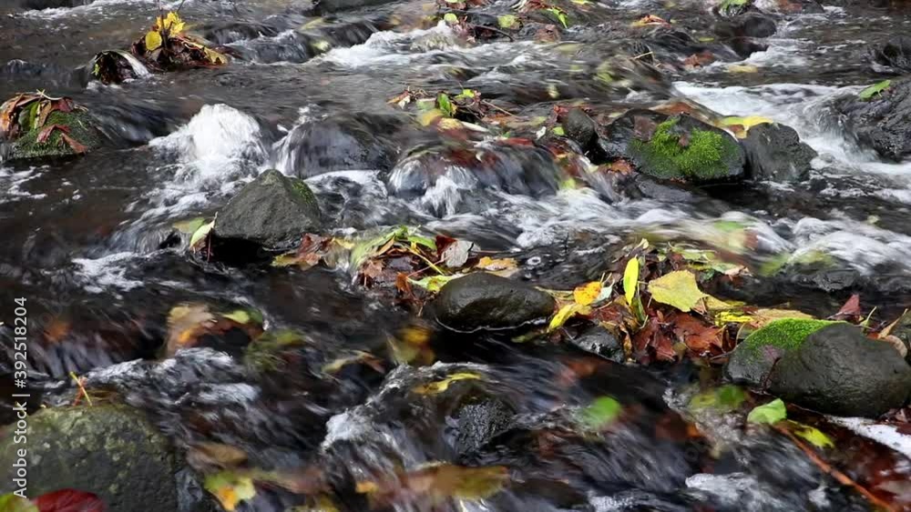 A water cascade in autumn river, close up.