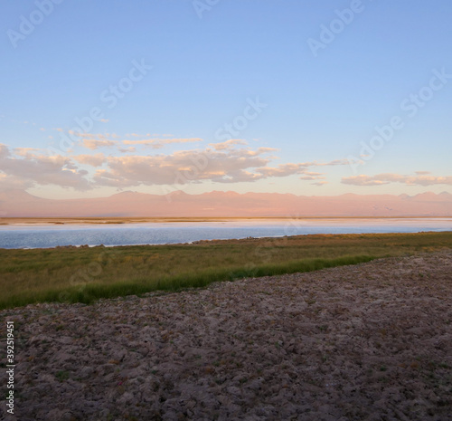 Sunset over salt lake in Atacama desert with orange mountains  Chile