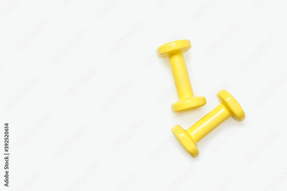 Yellow dumbbells isolated on white background. View from above. Yellow dumbbells isolated on white background. View from above.