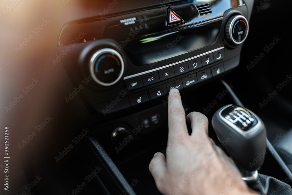 Fototapeta premium Interior view of a modern new car. Climate or air conditioner system adjusted by a man. Adjusting temperature of car's interior