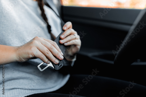 MURES, ROMANIA - OCTOBER 21, 2020, interior view of brand new Hyundai Tucson 2020. Young female driver using seat belt in the car before traveling