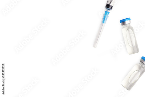 Covid 19 vaccine research and distribution. Two vaccine vial and needle syringe. Vaccination concept. Disease injection rescue care treatment. Coronavirus medical bottle. White background, copy space.