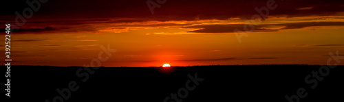 The sky and clouds are illuminated by the setting sun. Panorama.