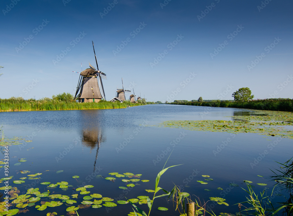 Kinderdijk, The Netherlands, August 2019. On a beautiful summer day the typical landscape of the place: historic windmills, in perfect condition, in the Dutch countryside furrowed by canals .