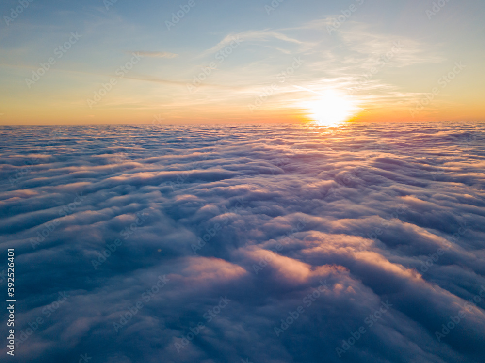 Sunset over curly clouds, aerial high flight. The last rays of the sun shine on the clouds. Sunset over curly clouds, aerial high flight. The last rays of the sun shine on the clouds.