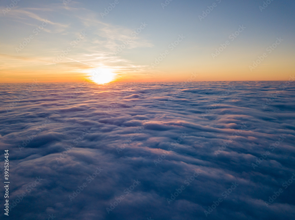 Sunset over curly clouds, aerial high flight. The last rays of the sun shine on the clouds. Sunset over curly clouds, aerial high flight. The last rays of the sun shine on the clouds.