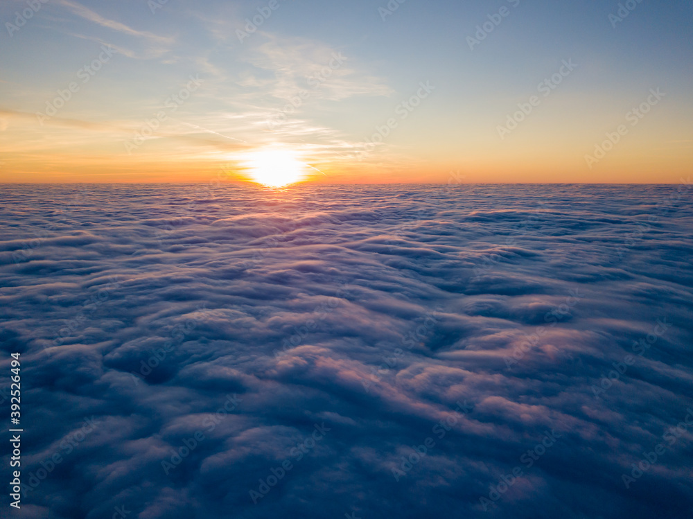 Sunset over curly clouds, aerial high flight. The last rays of the sun shine on the clouds. Sunset over curly clouds, aerial high flight. The last rays of the sun shine on the clouds.