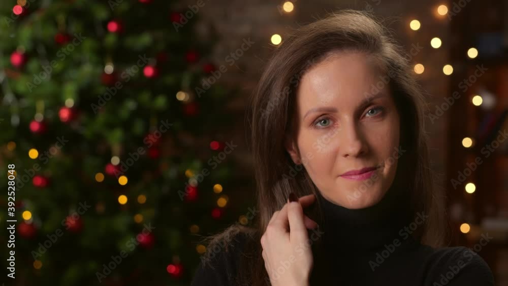 Portrait of young woman at home smiling, Christmas tree in background. Portrait of young woman at home smiling, Christmas tree in background.