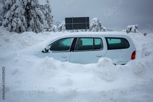Car stuck in deep snow on mountain road - winter traffic problem photo