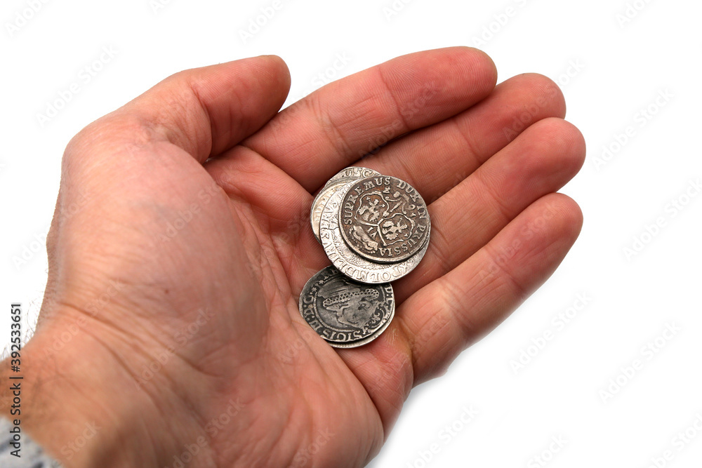 Ancient silver coins in hand on white background Ancient silver coins in hand on white background