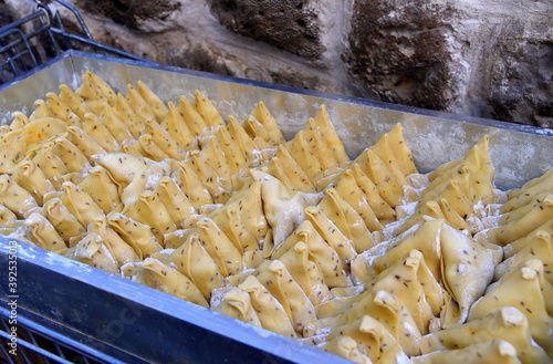 Zum Frittieren vorbereitete, gefüllte Teigtaschen auf einem Blech photo