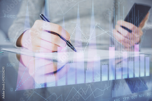 Double exposure of forex chart sketch hologram and woman holding and using a mobile device. Financial market concept.