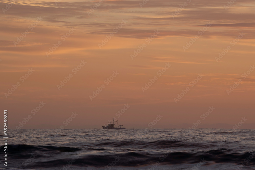 A boat on the hozizon at Sunrise at Turimetta Beach A boat on the hozizon at Sunrise at Turimetta Beach