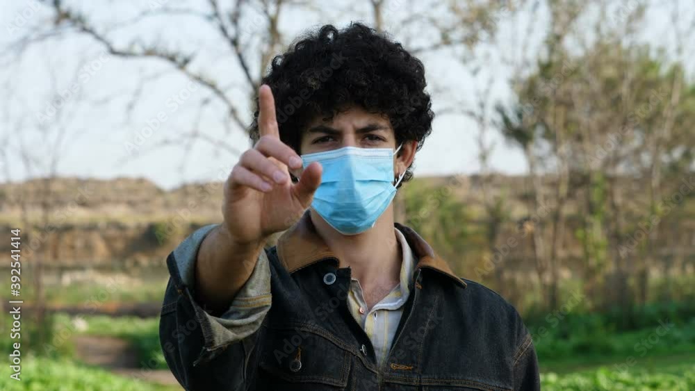 keep your distance - young man wearing mask makes no to the camera keep your distance - young man wearing mask makes no to the camera