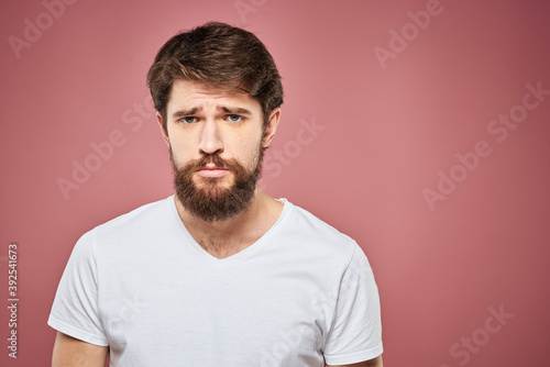 emotional man white t shirt sad facial expression pink background
