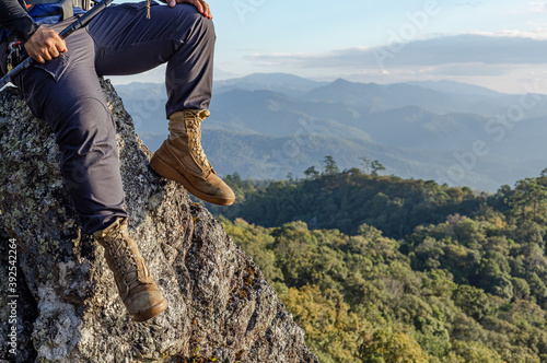 Male Hiker Boots Resting on Mountain Peak with Mountain Lakes in the Background