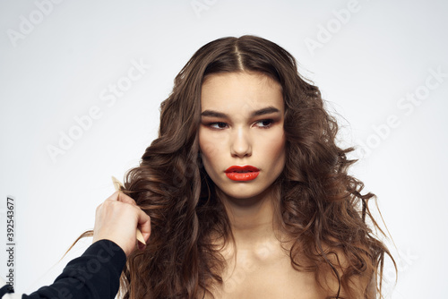 woman with bare shoulders wavy hairstyle glamor makeup light background