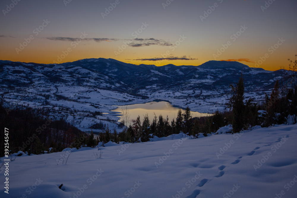 Colorful sunset evening at mountain lake in snow, beautiful nature winter scene Colorful sunset evening at mountain lake in snow, beautiful nature winter scene