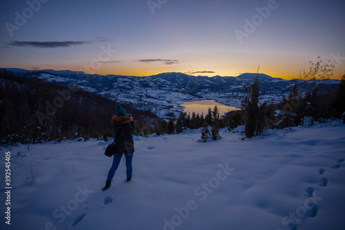 Photographers photographing winter lake mountain scene in sunset, alone in wilderness