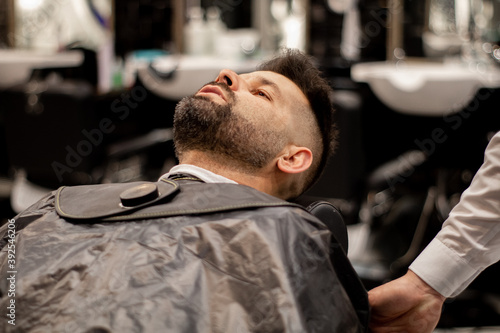 Client lying on a barber shop chair