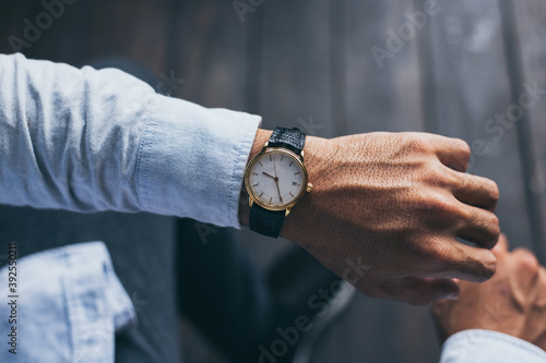 men fashionable wearing stylish looking at luxury watch on hand check the time at workplace.concept for managing time organization working,punctuality,appointment