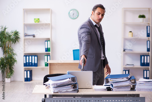 Young employee angry with excessive work holding firearm weapon