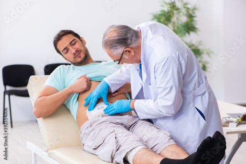 Injured young man visiting experienced male doctor