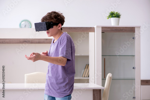 Schoolboy wearing virtual glasses at home