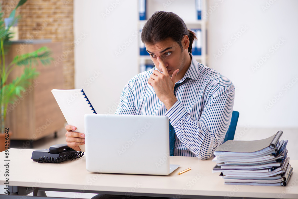 Young male employee working in the office Young male employee working in the office