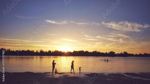 Siluetas de una familia en la playa al atardecer © ameaz_23