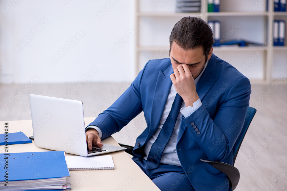 Young male employee working at workplace Young male employee working at workplace