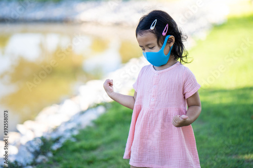 Cute little girl walking outdoor wearing healthy face mask prevent virus and PM2.5