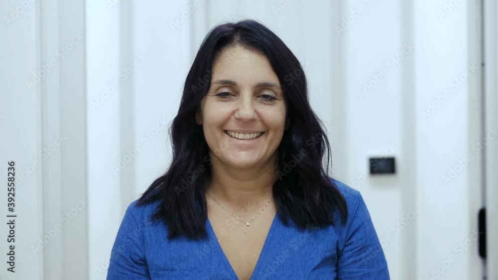 confidence, hope - serious woman changes expression and smile at camera