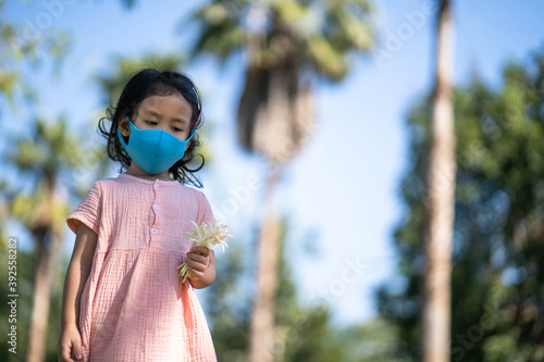 Cute little girl walking outdoor wearing healthy face mask prevent virus and PM2.5