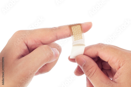 Brown medicine bandage on injured finger on white background.