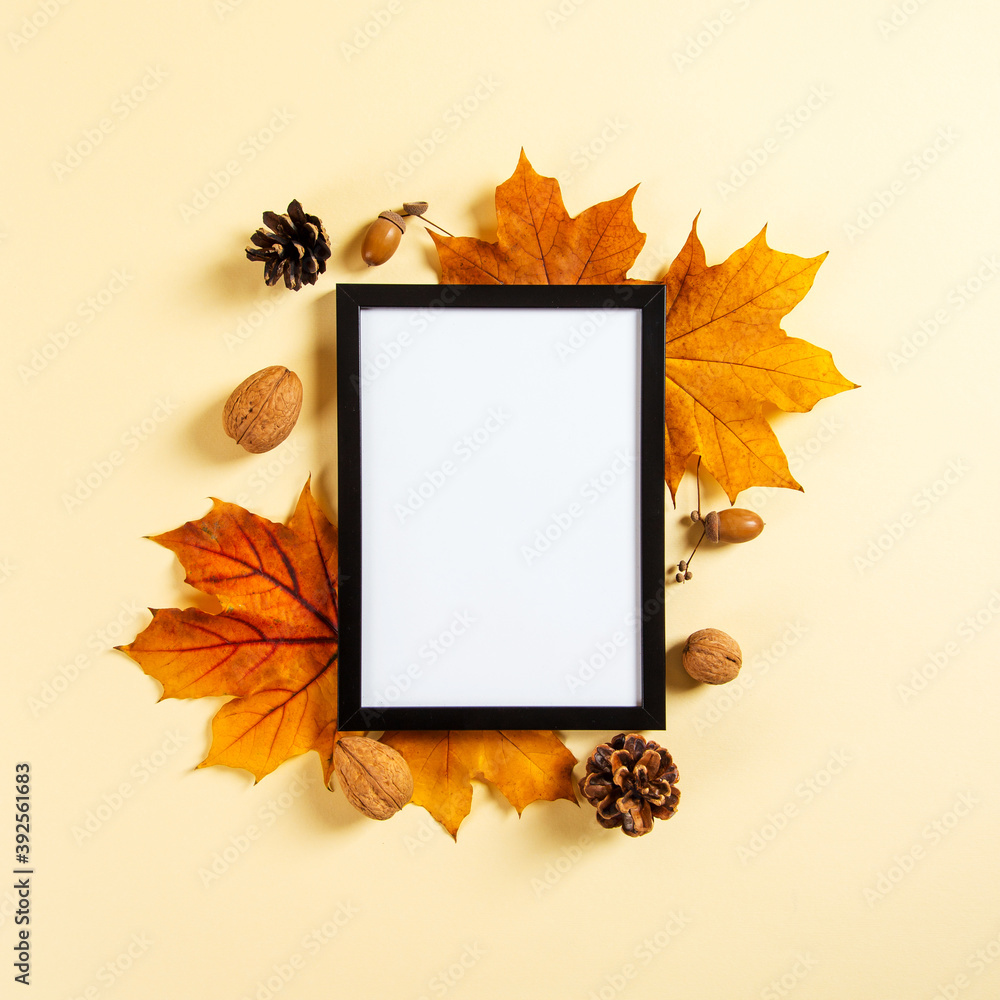 Frame and autumn leaves and berries on a yellow background, mockup for design, place for text, concept of autumn. Copy space.