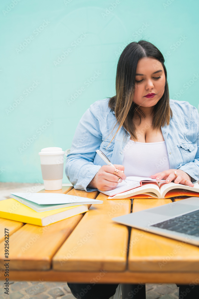 Plus size woman studying at coffee shop. Plus size woman studying at coffee shop.