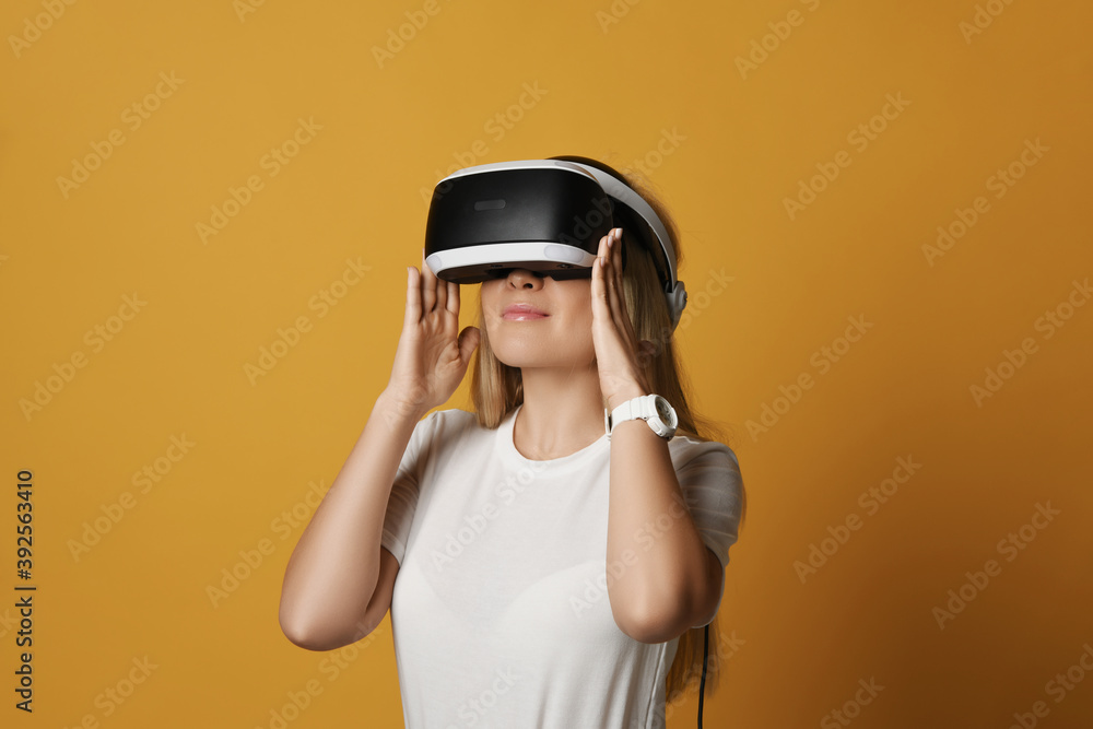 Young blonde woman in white t-shirt takes on vr glasses to explore virtual augmented reality. Woman in cyber space and virtual gaming. Discovering future and latest advanced technologies Young blonde woman in white t-shirt takes on vr glasses to explore virtual augmented reality. Woman in cyber space and virtual gaming. Discovering future and latest advanced technologies