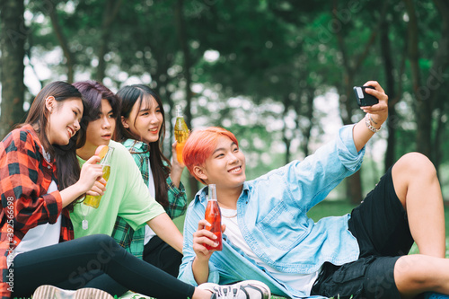 Group of happy young Asians are taking pictures check-in together at the park