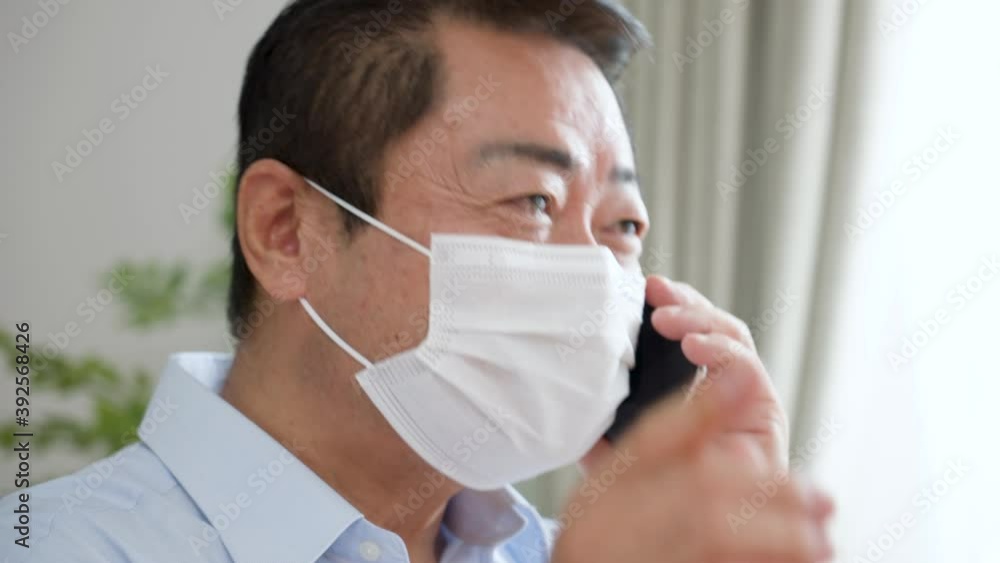 携帯電話で話をする中年男性 携帯電話で話をする中年男性