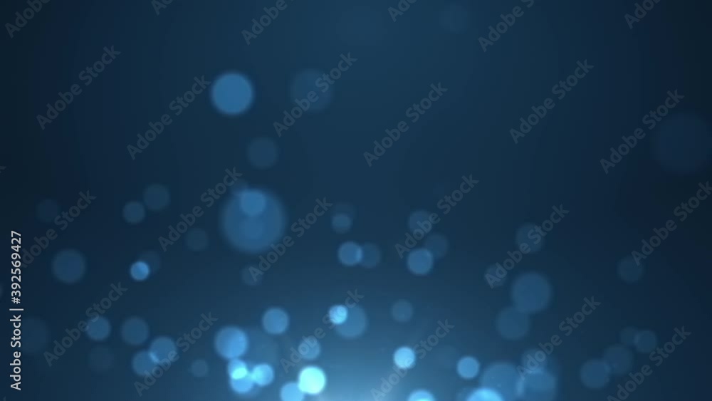 Transparent glittery orbs of bokeh flickering magically as they elevate with the breeze and dissipate away in a blue lit ambience motion background.