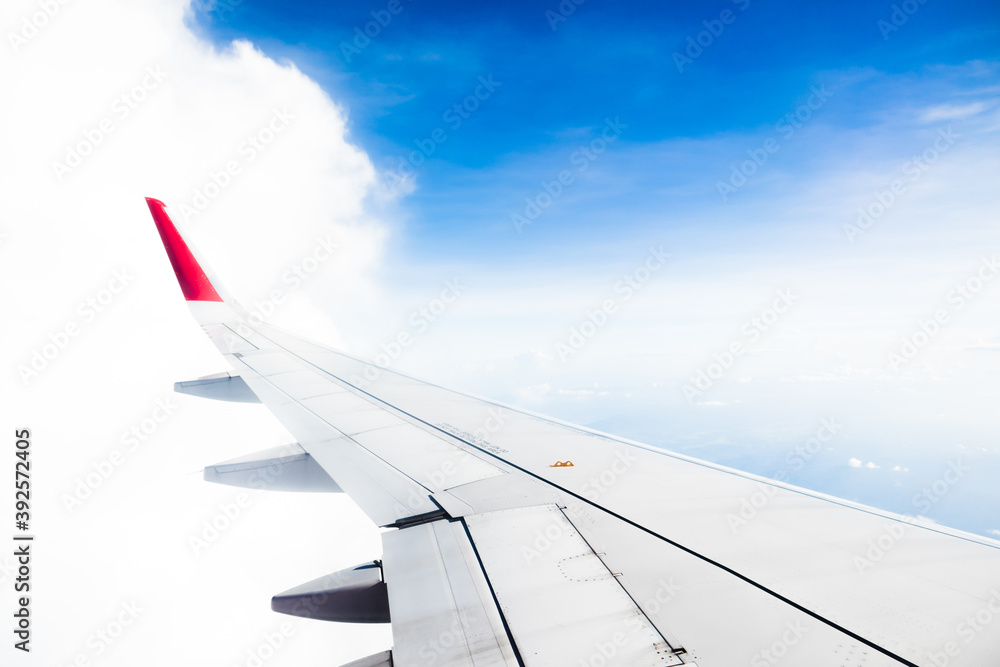 View from airplane on the aircraft white wing flying over blue sky and white clouds.Air travel and transportation concept.