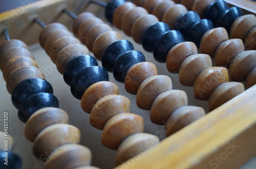 Close-up of wooden Russian abacus. A simple mechanical device, a counting board with dice, for performing arithmetic calculations. Vintage dusty item