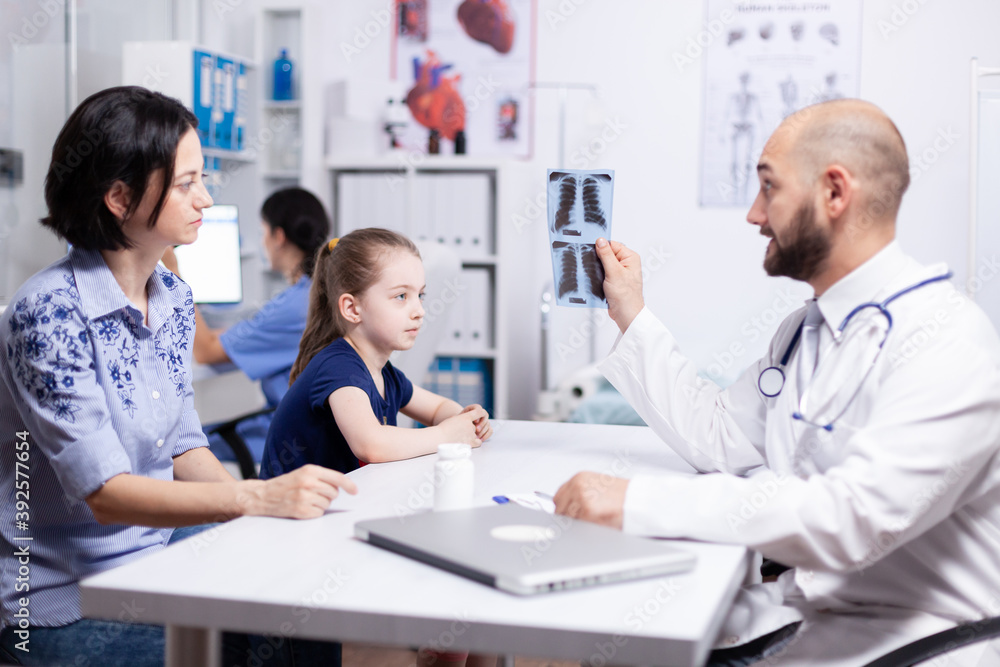 Pediatrician examining sick child radiography during medical consultation. Healthcare physician specialist in medicine providing health care services treatment examination. Pediatrician examining sick child radiography during medical consultation. Healthcare physician specialist in medicine providing health care services treatment examination.