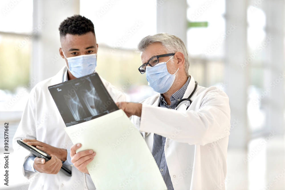 Doctor with medical intern analysing XR results Doctor with medical intern analysing XR results